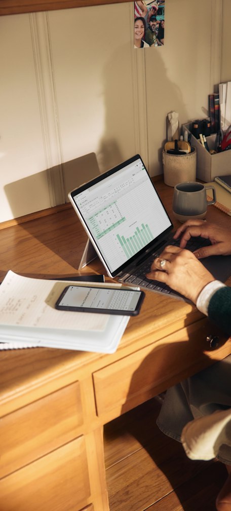 Person working on laptop at a wooden desk