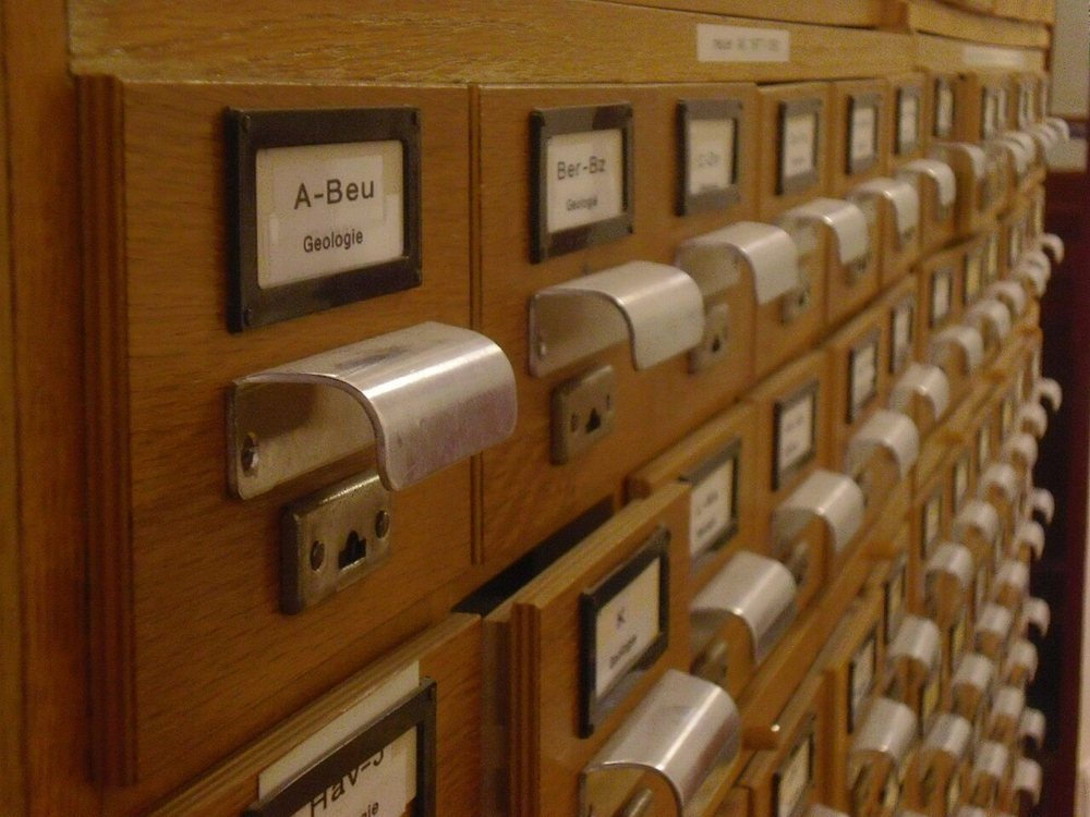 An index card cabinet with labelled drawers: one record per contact