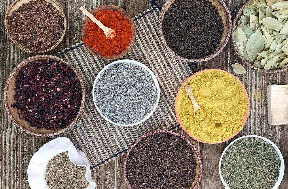 Spices in bowls with wooden spoons seen from above
